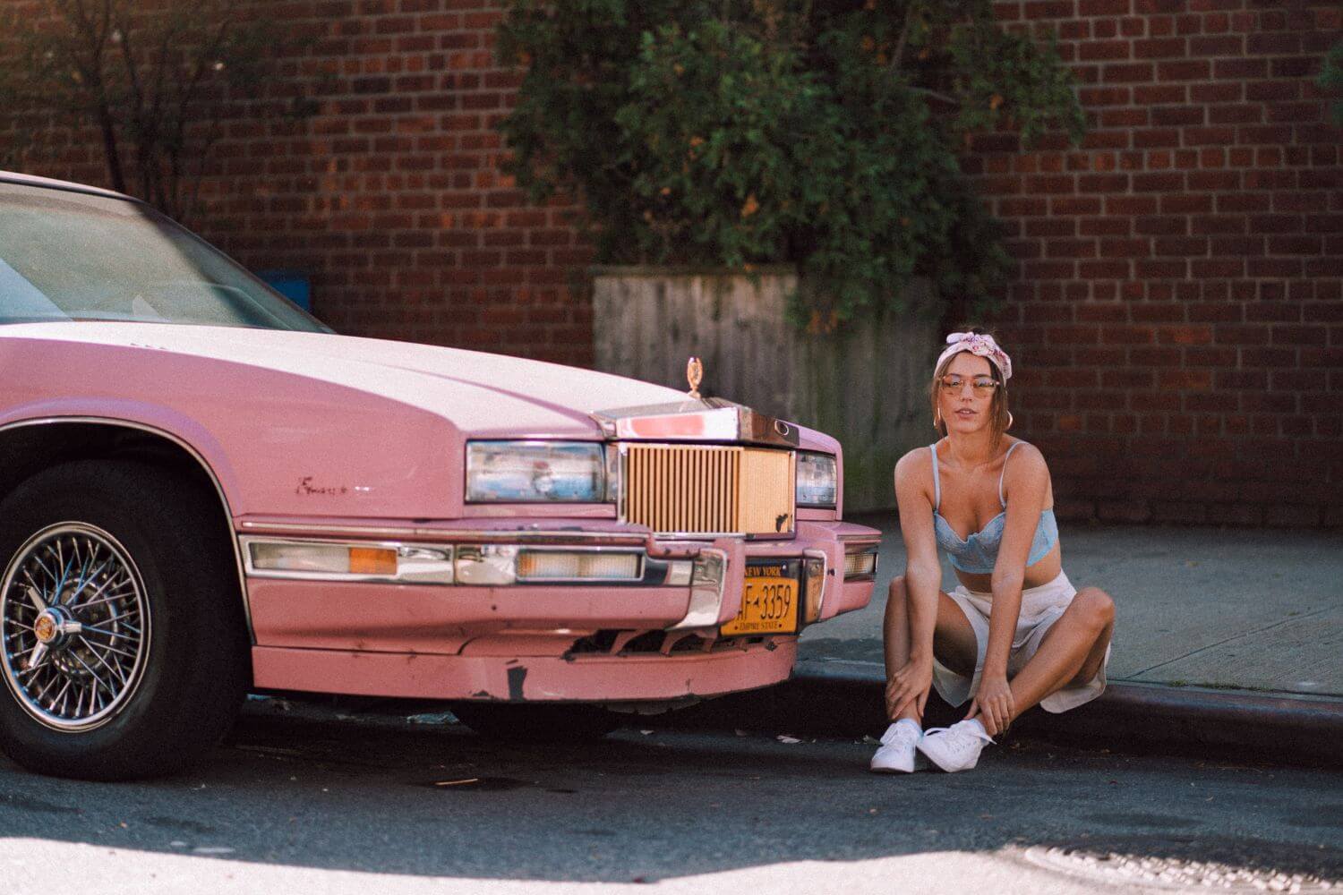 film photo of a pink car and girl in a vintage aesthetic