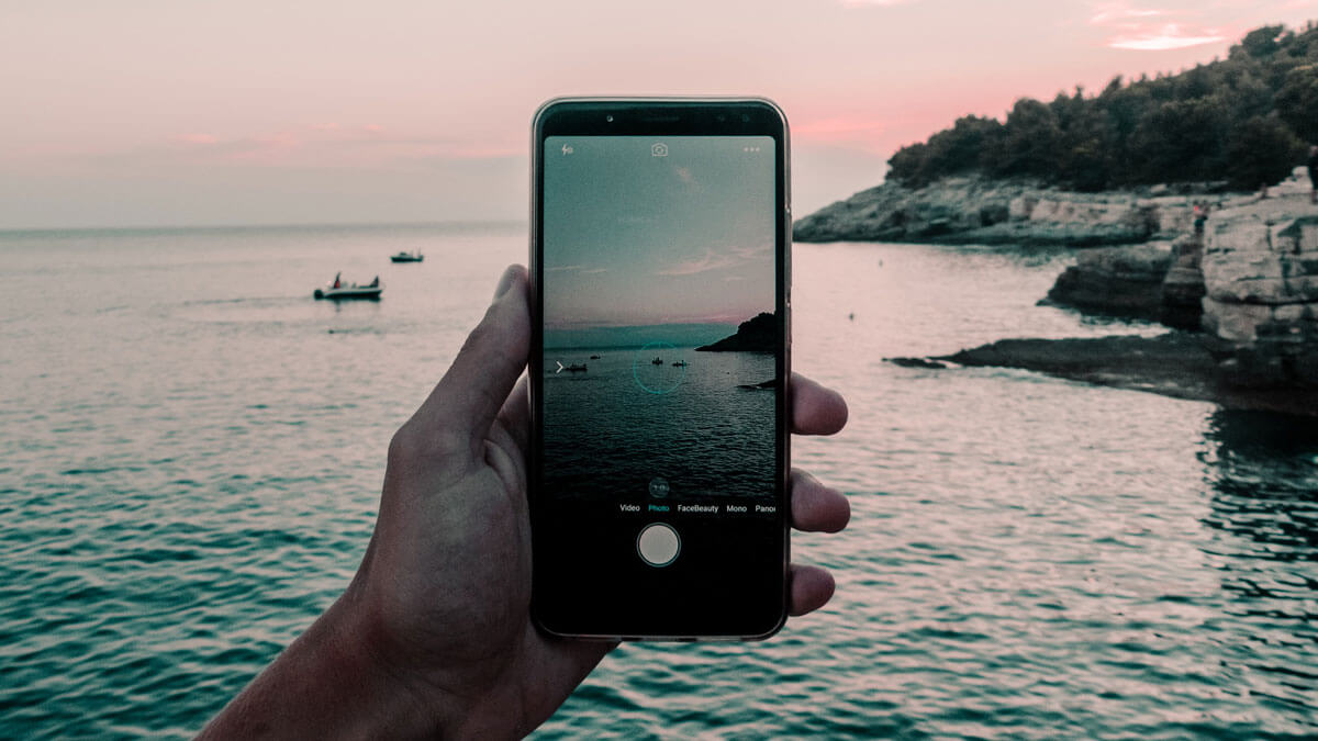 vintage-photo-editing-and-camera-app-capturing-a-picture-on-phone-of-a-sunset-at-sea