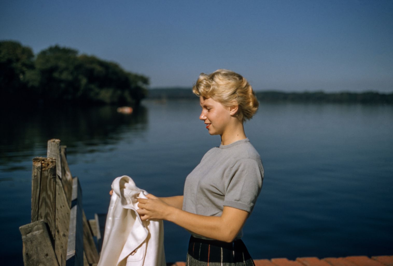 vintage portrait of blonde woman on a dock by the lake