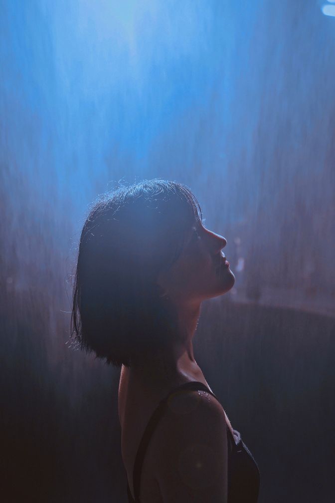 vintage portrait with light leaks of a girl in the rain